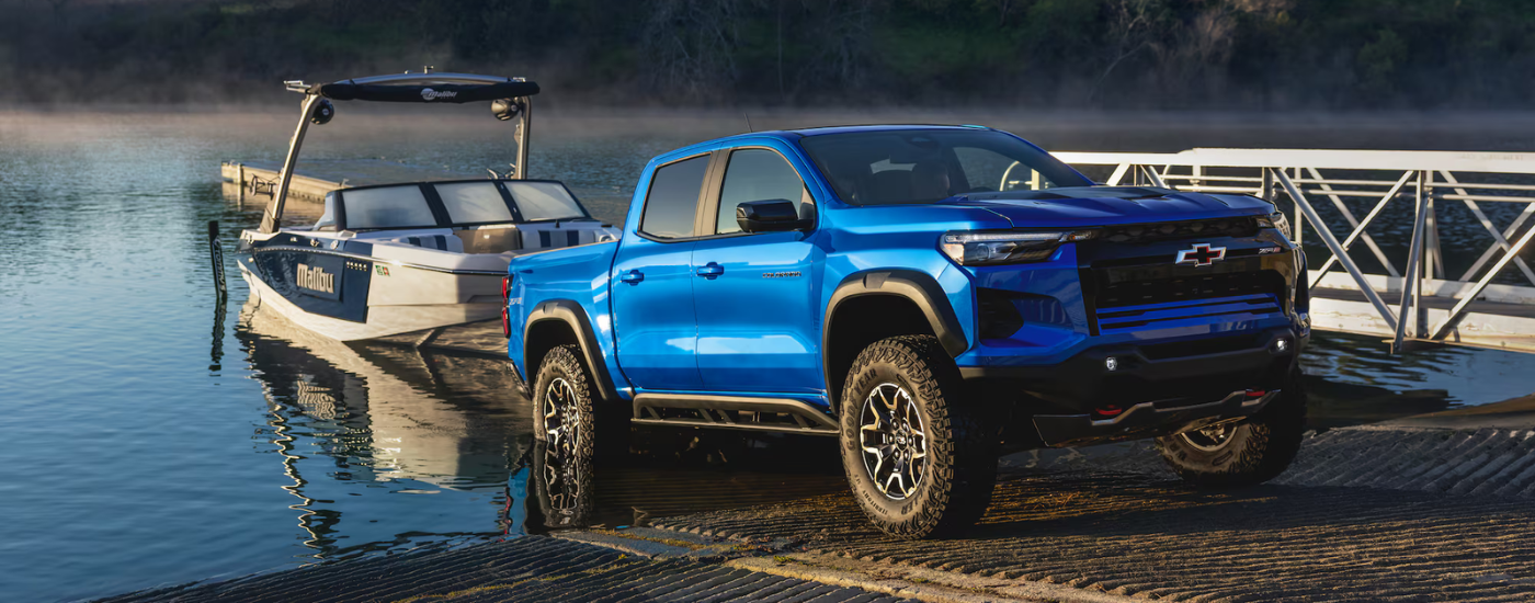 Blue 2026 Chevy Colorado ZR2 towing a boat out of a lake