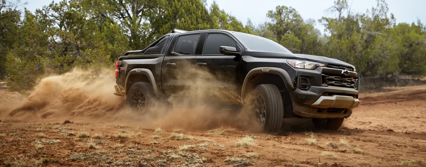 Black 2026 Chevy Colorado off-roading on a dusty dirt road