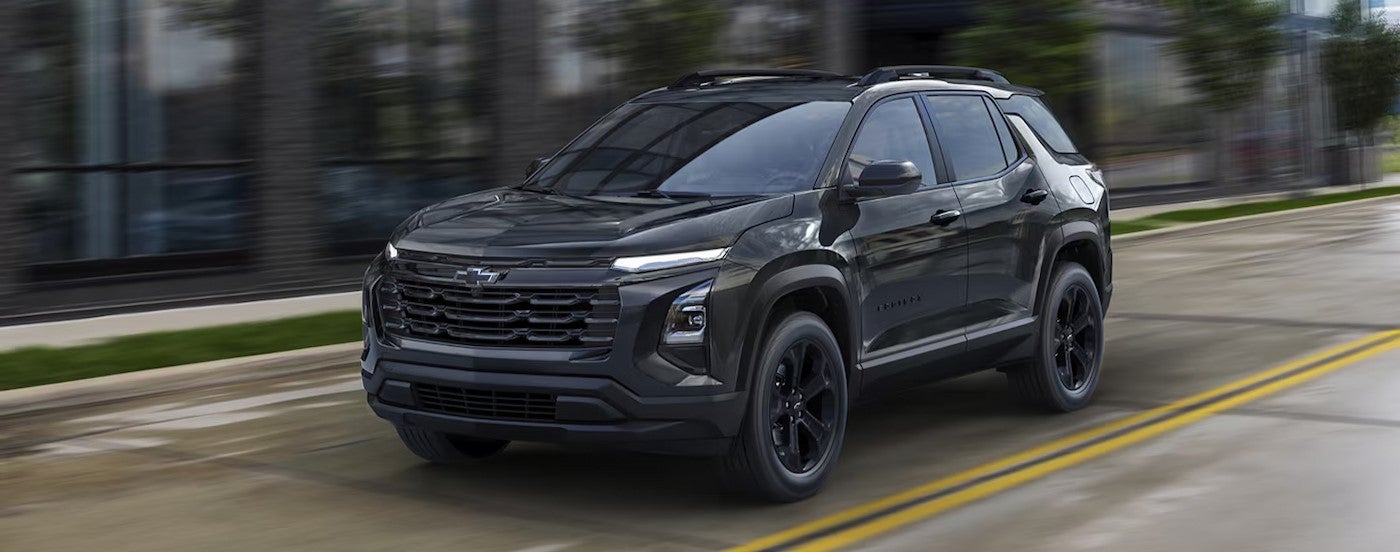 A black 2026 Chevy Equinox driving on a city street.