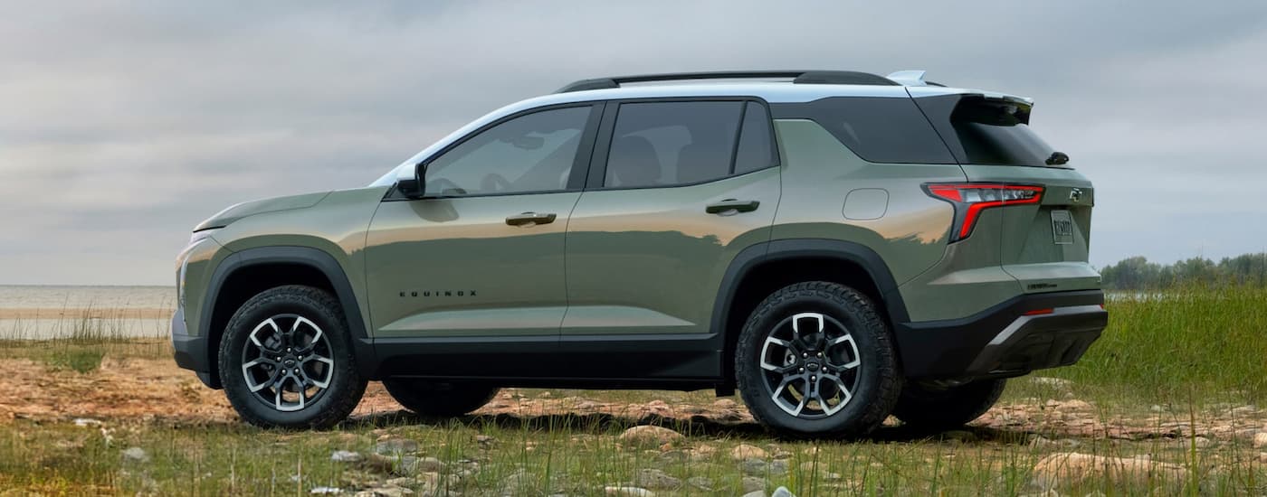 Rear of a green 2026 Chevy Equinox ACTIV parked on grass.