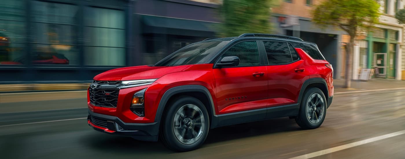 Red 2026 Chevy Equinox RS driving down a road.