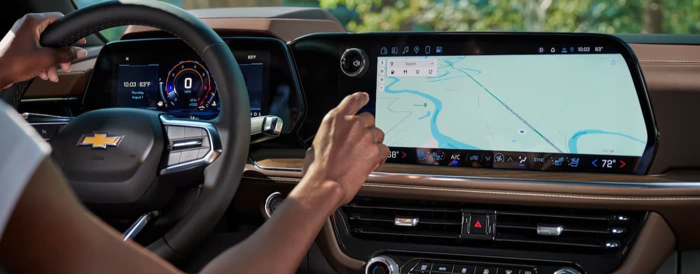 A person using the infotainment screen in a 2026 Chevy Tahoe.