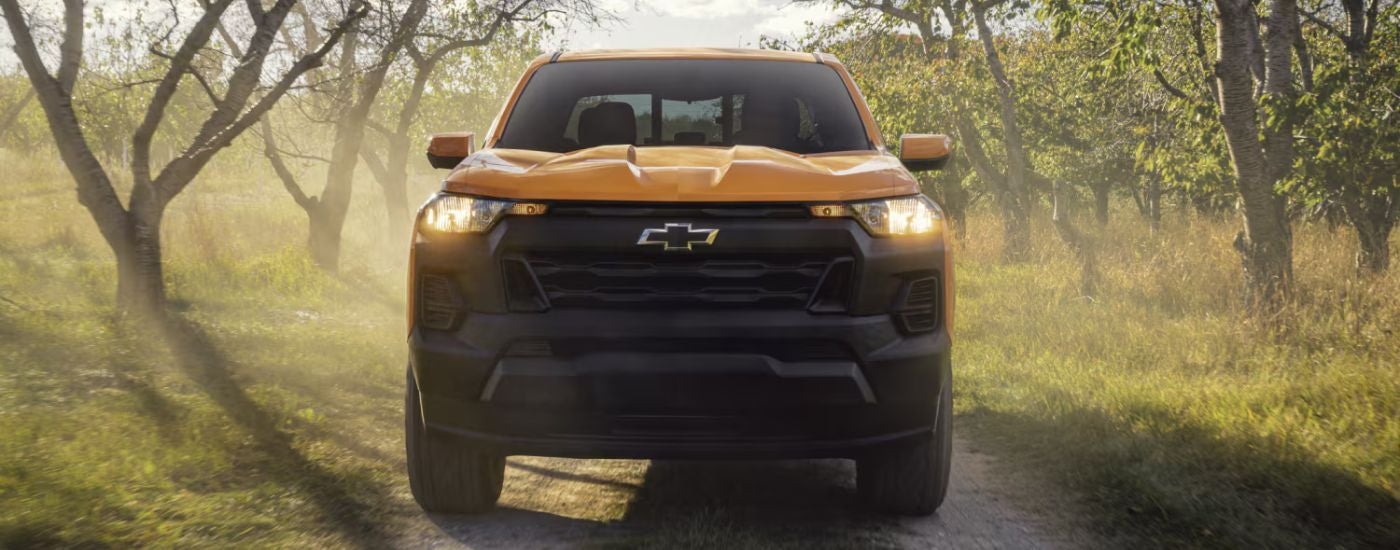 Front view of a yellow 2026 Chevy Colorado driving off-road.