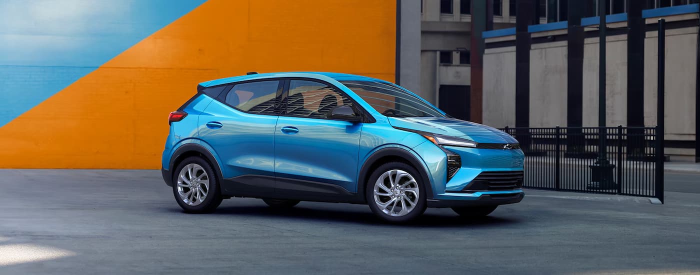 A blue 2027 Chevy Bolt parked in a city