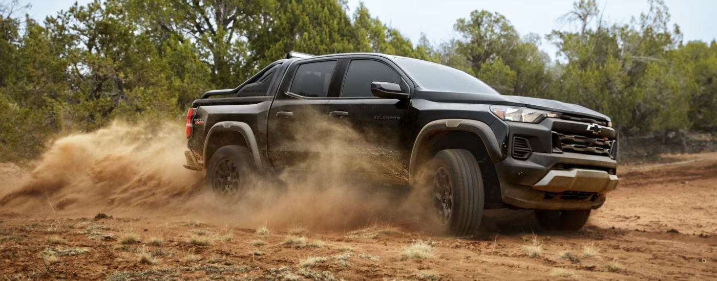 A black 2026 Chevy Colorado Trail Boss Midnight Edition kicking up dust.