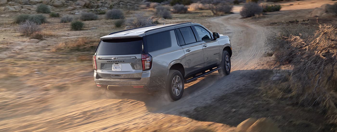 A silver 2022 Chevy Suburban driving to a Bigfoot Chevy dealership.