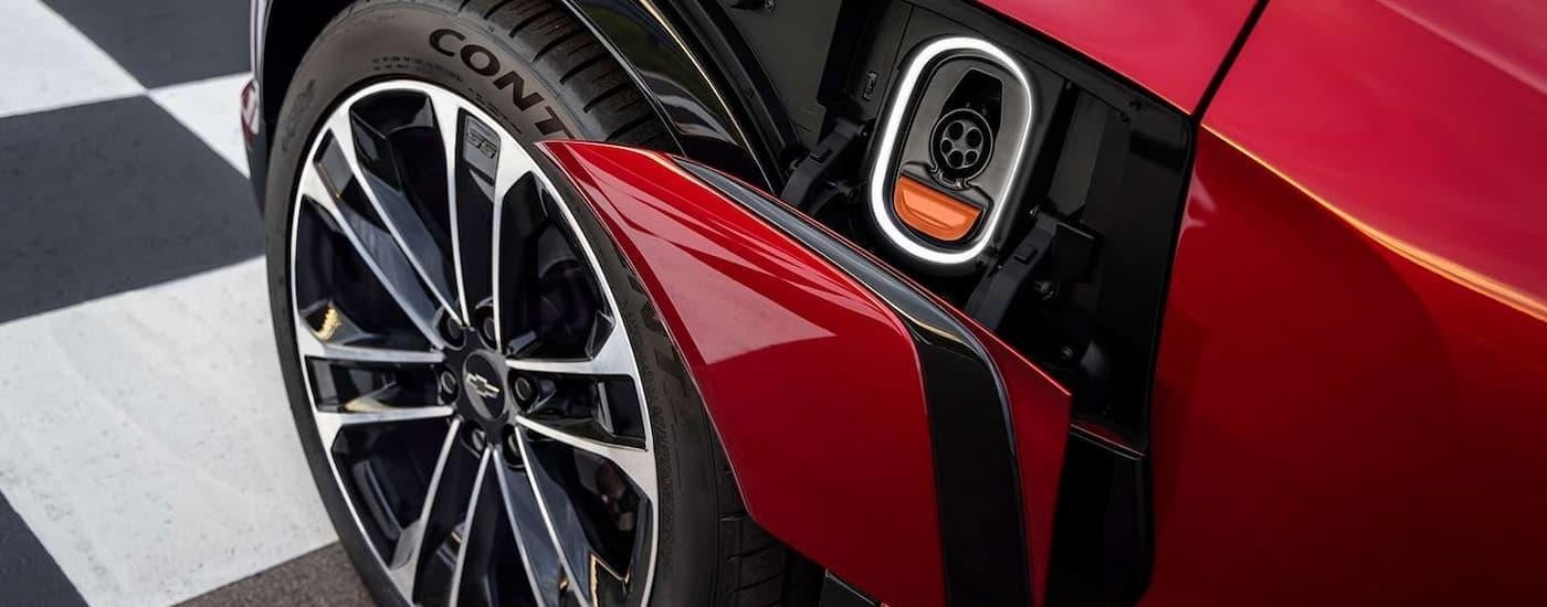 A close up of the EV charging port on a red 2024 Chevy Blazer EV is shown.