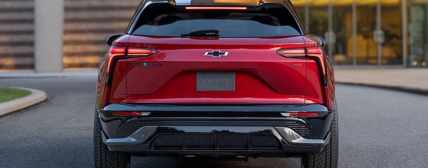 A red 2024 Chevy Blazer EV SS is shown from the rear while parked at a dealer.