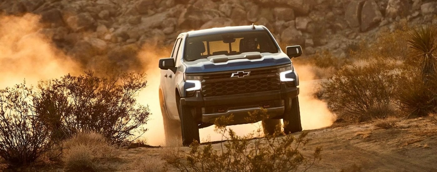 A blue 2022 Chevy Silverado 1500 ZR2 driving to a Castroville Chevy dealership.