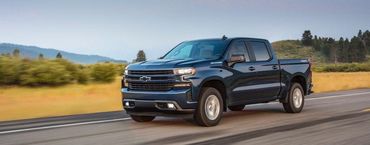 A blue 2020 Chevy Silverado 1500 driving on a highway.