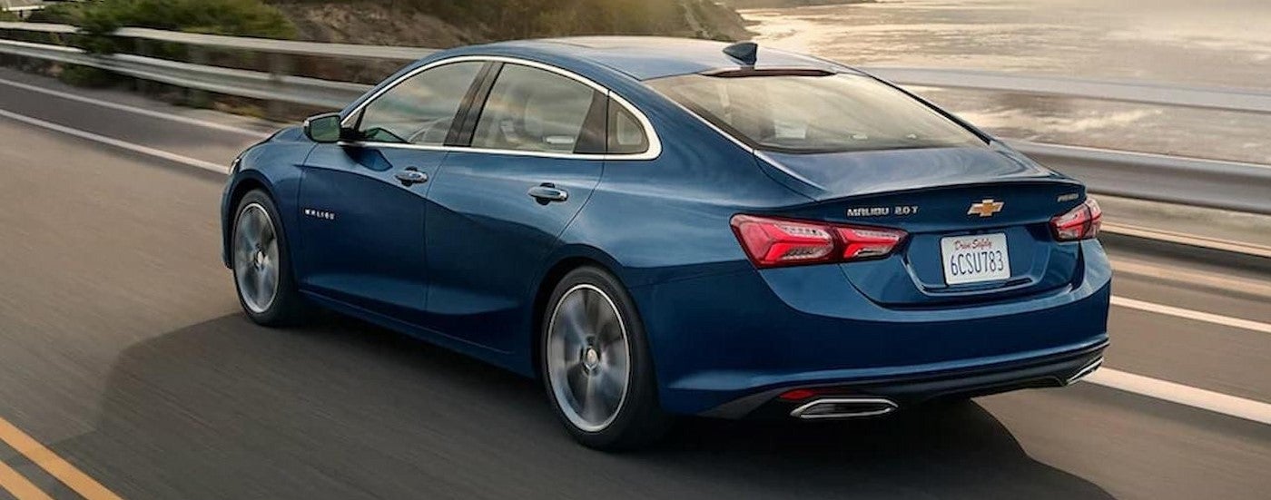 A blue 2022 Chevy Malibu driving on a highway.