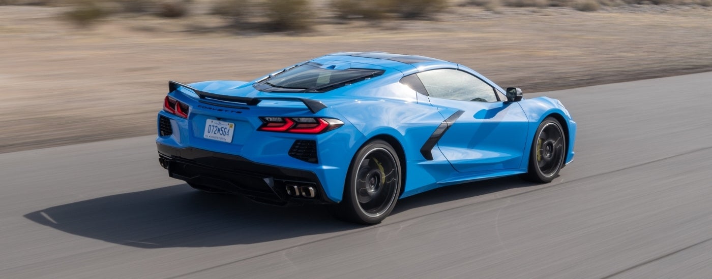 A blue 2023 Chevy Corvette driving to a Chevy dealer.