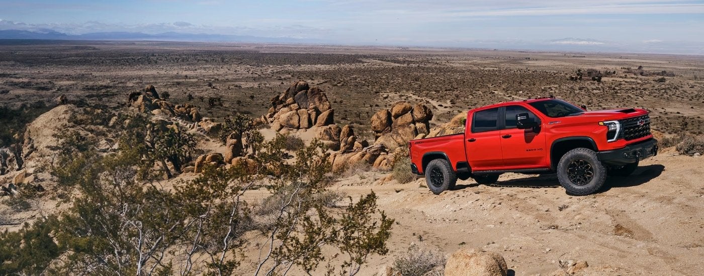 A red 2025 Chevy Silverado 2500 HD ZR2 parked off-road.