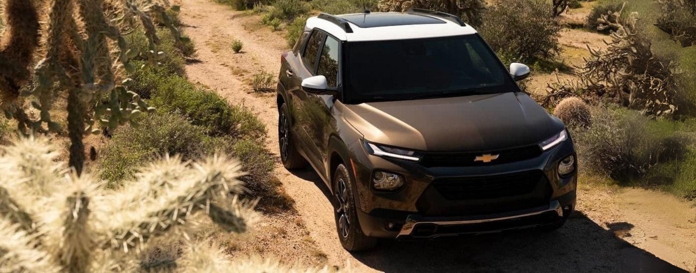 A bronze 2021 Chevy Blazer Activ driving to a Chevy Dealer