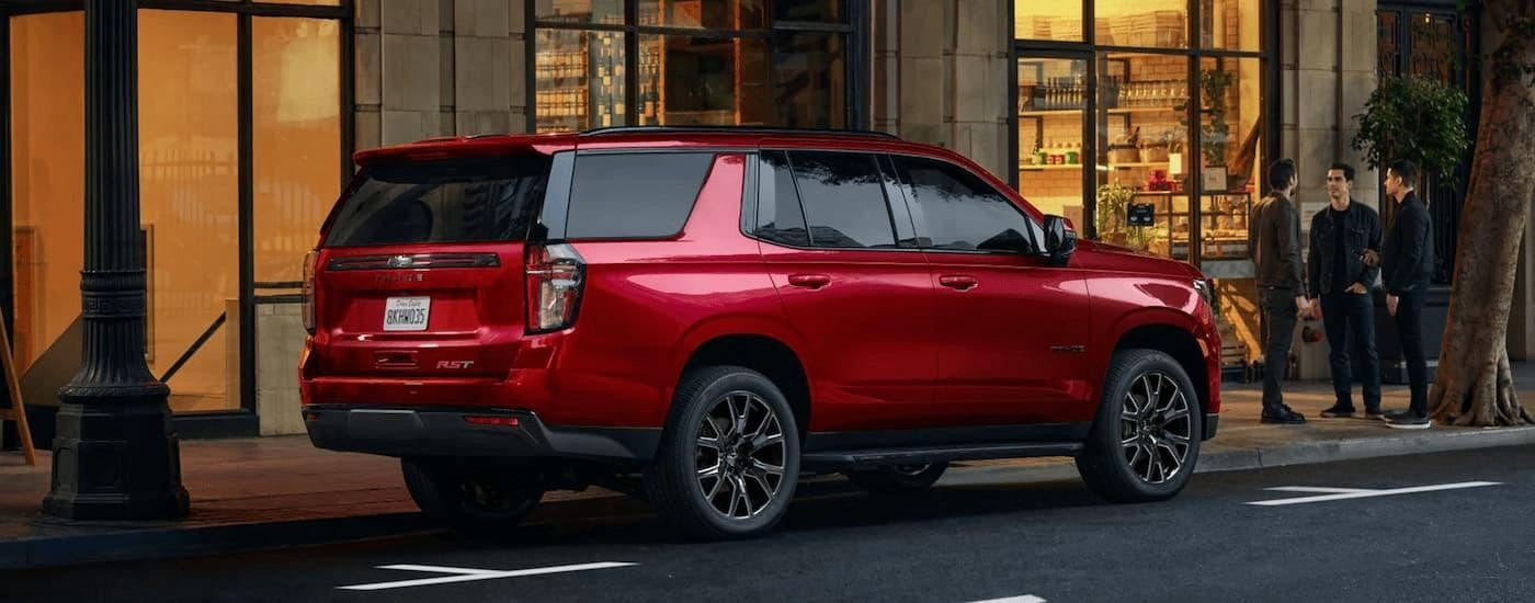 A red 2023 Chevy Tahoe RST parked on a city street.