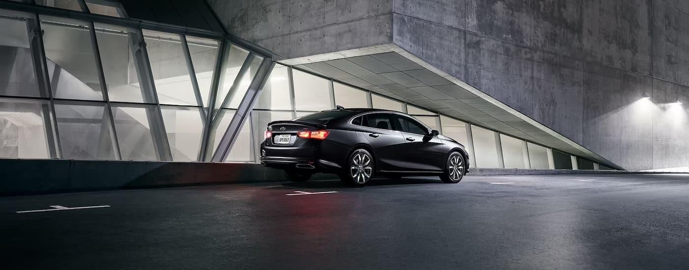 A black 2024 Chevy Malibu RS parked at night.