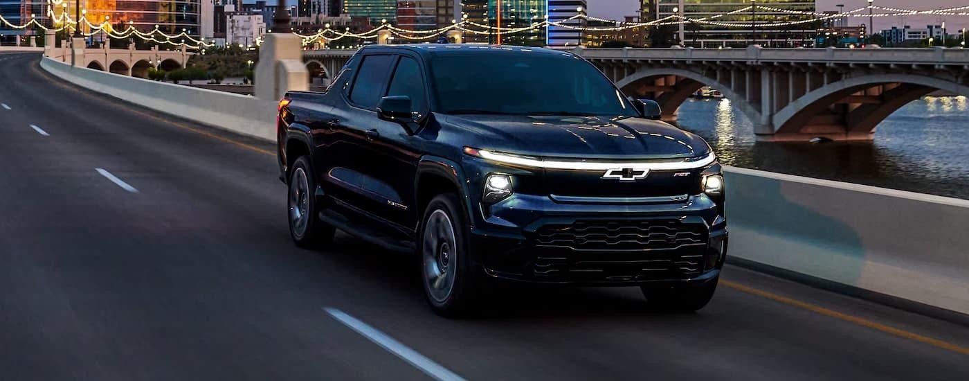 A black 2025 Chevy Silverado EV for Sale in Castroville is driving on a highway.
