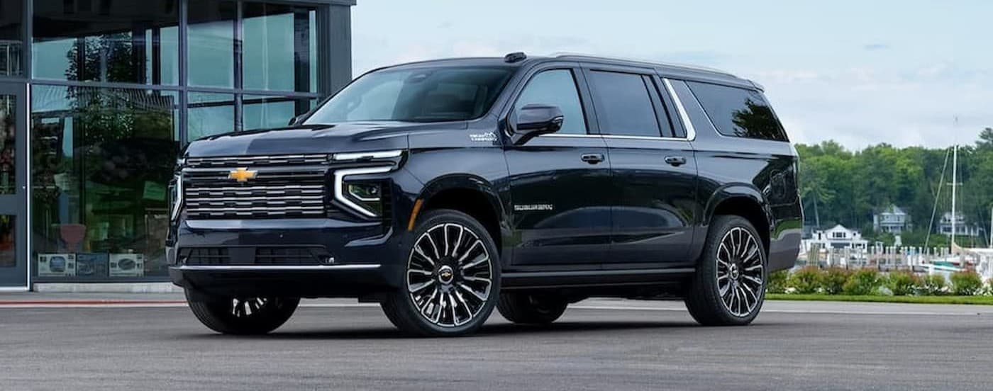 A blue 2026 Chevy Suburban parked near a dealership.