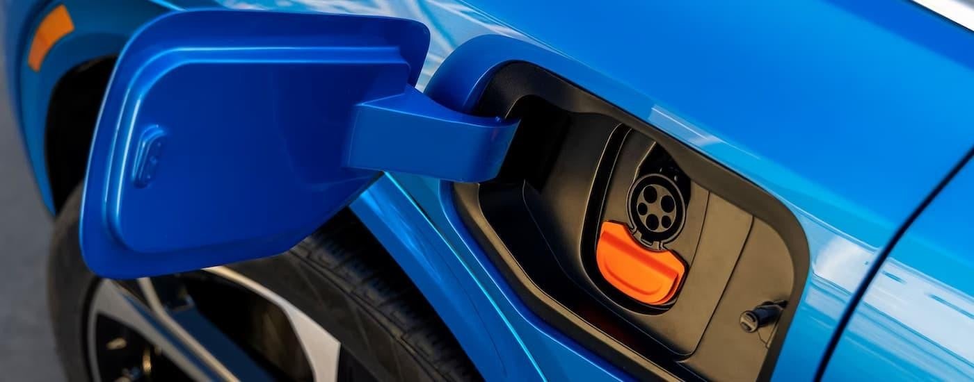 A close up of the charging port on a blue 2025 Chevy Equinox EV SLT.