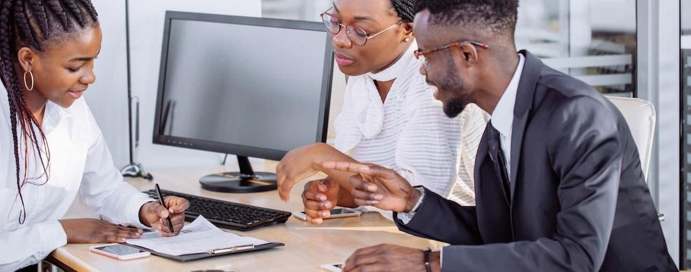 A couple talking to a salesperson about GM Purchase Programs.