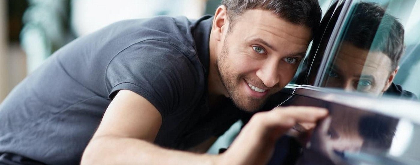 A person looking at a car in Oak Grove Chevrolet dealer.