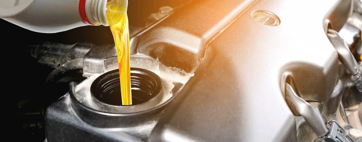 A close up of oil being poured into an engine during an oil change.