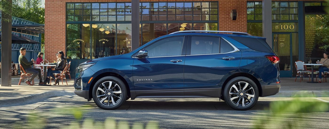 A blue 2022 Chevy Equinox parked in front of a building.