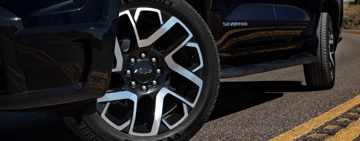 A close up of the front tire and rim on a black 2025 Chevy Silverado EV for sale near San Antonio.
