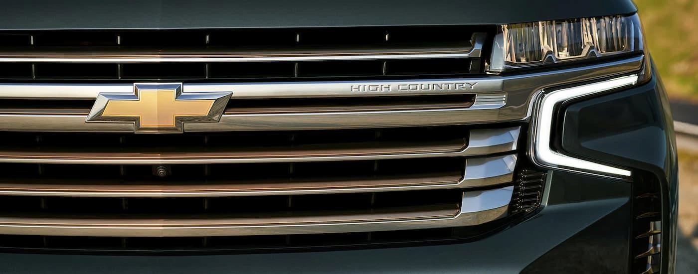 A close up of the grille on a green 2022 Chevy Tahoe High Country.