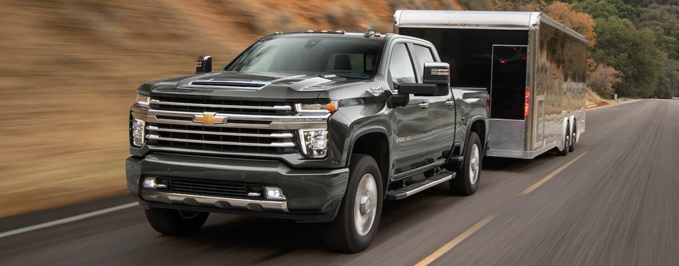 Black 2022 Chevy Silverado 2500 HD towing a trailer.