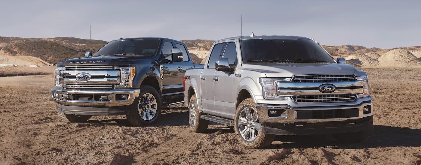 A silver and blue 2018 Ford F-250 are shown parked in a desert after looking at used trucks for sale in Castroville, TX.