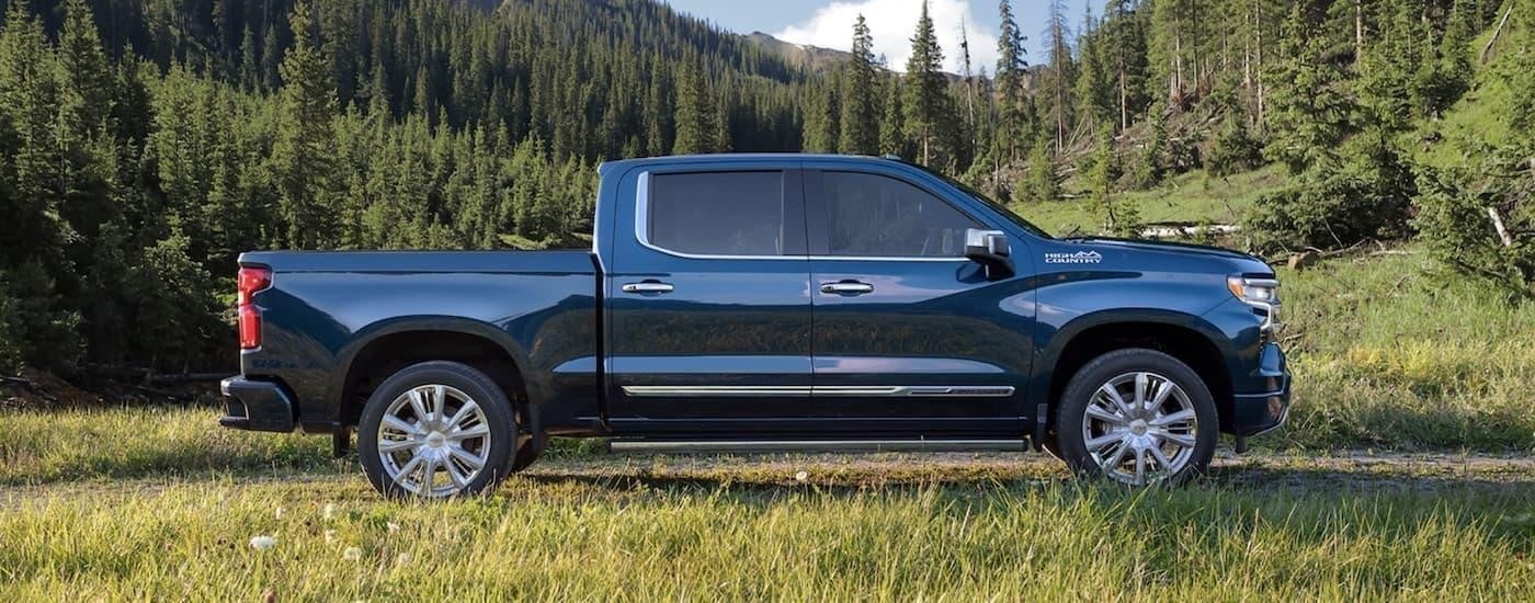 A blue 2022 Chevy Silverado 1500 is shown from the side parked in a field after searching used trucks for sale near San Antonio.