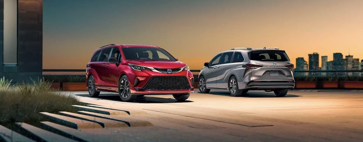 A silver 2022 Toyota Sienna XSE and a red 2022 Toyota Sienna XSE PLUS on a parking pad.